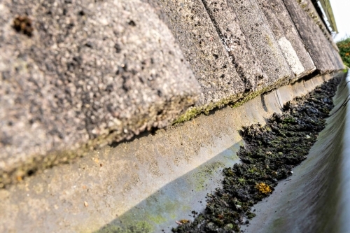 Tagrende med snavs og blade før rensning